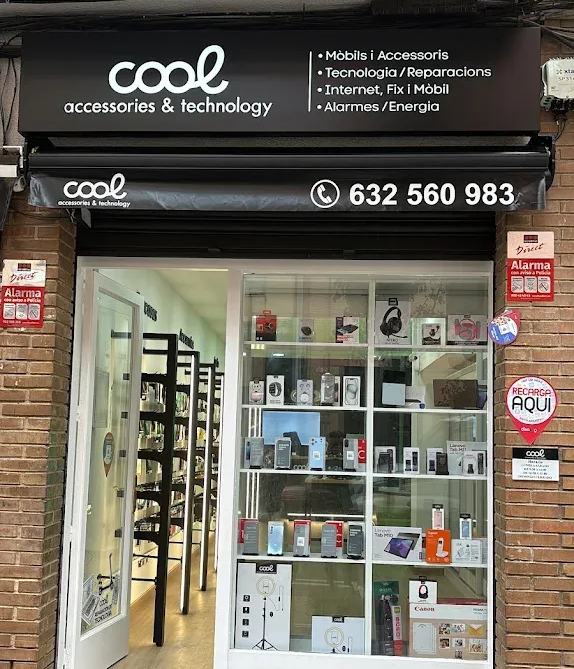 Fachada de una pequeña tienda de accesorios para móviles, con un letrero negro, escaparate de cristal y entrada abierta.