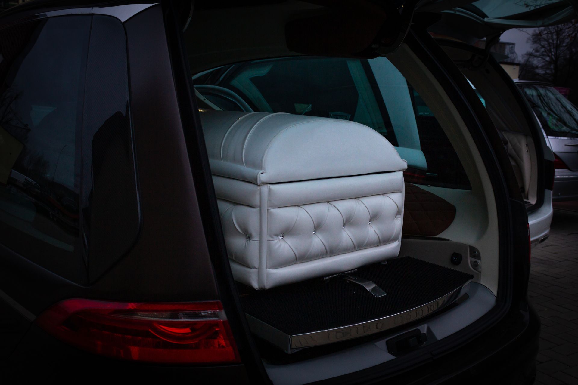 Un cercueil blanc dans un corbillard