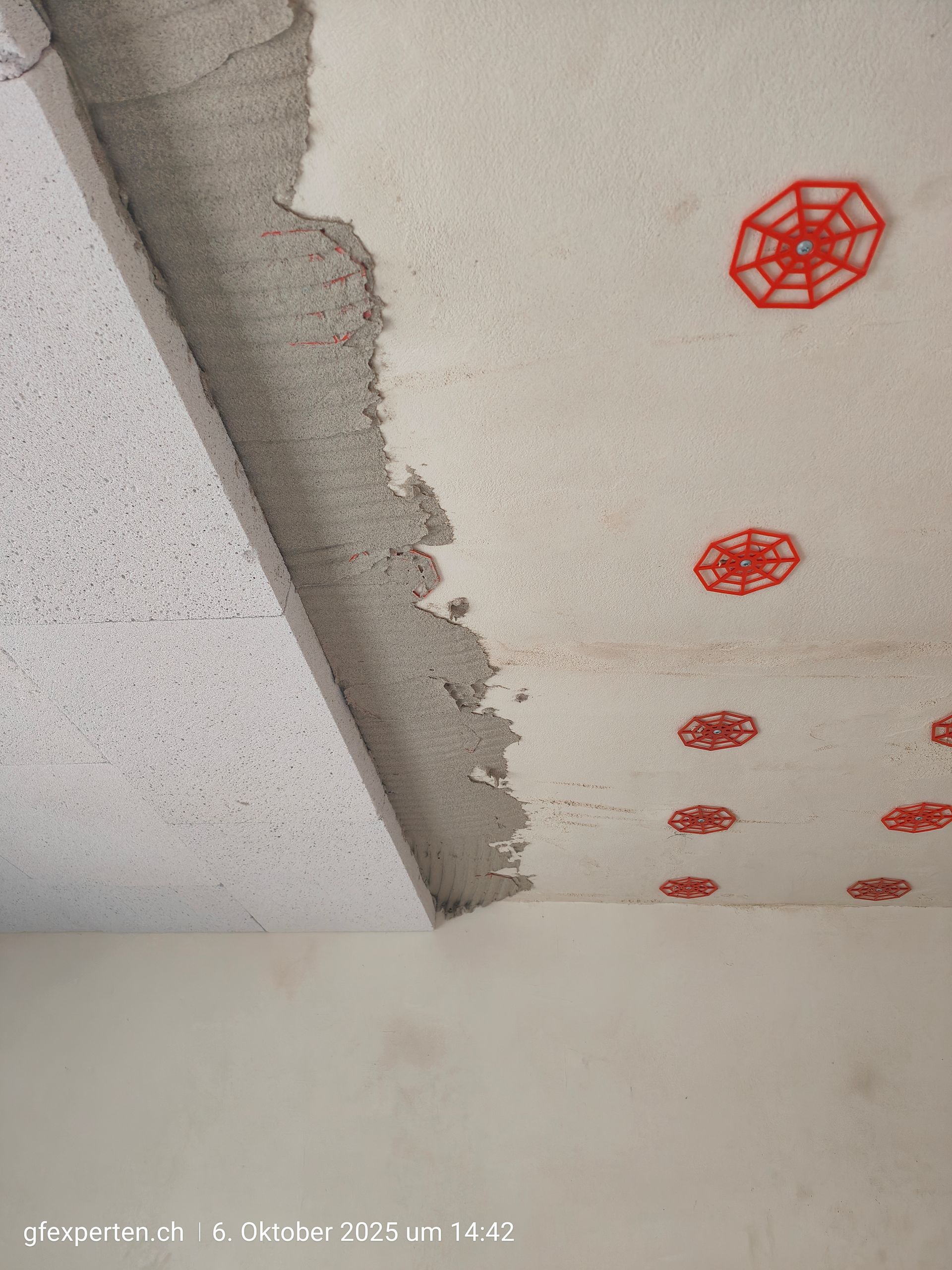 Innenansicht eines im Bau befindlichen Raumes mit freiliegenden Holzbalken, Lüftungskanälen und Dämmung.