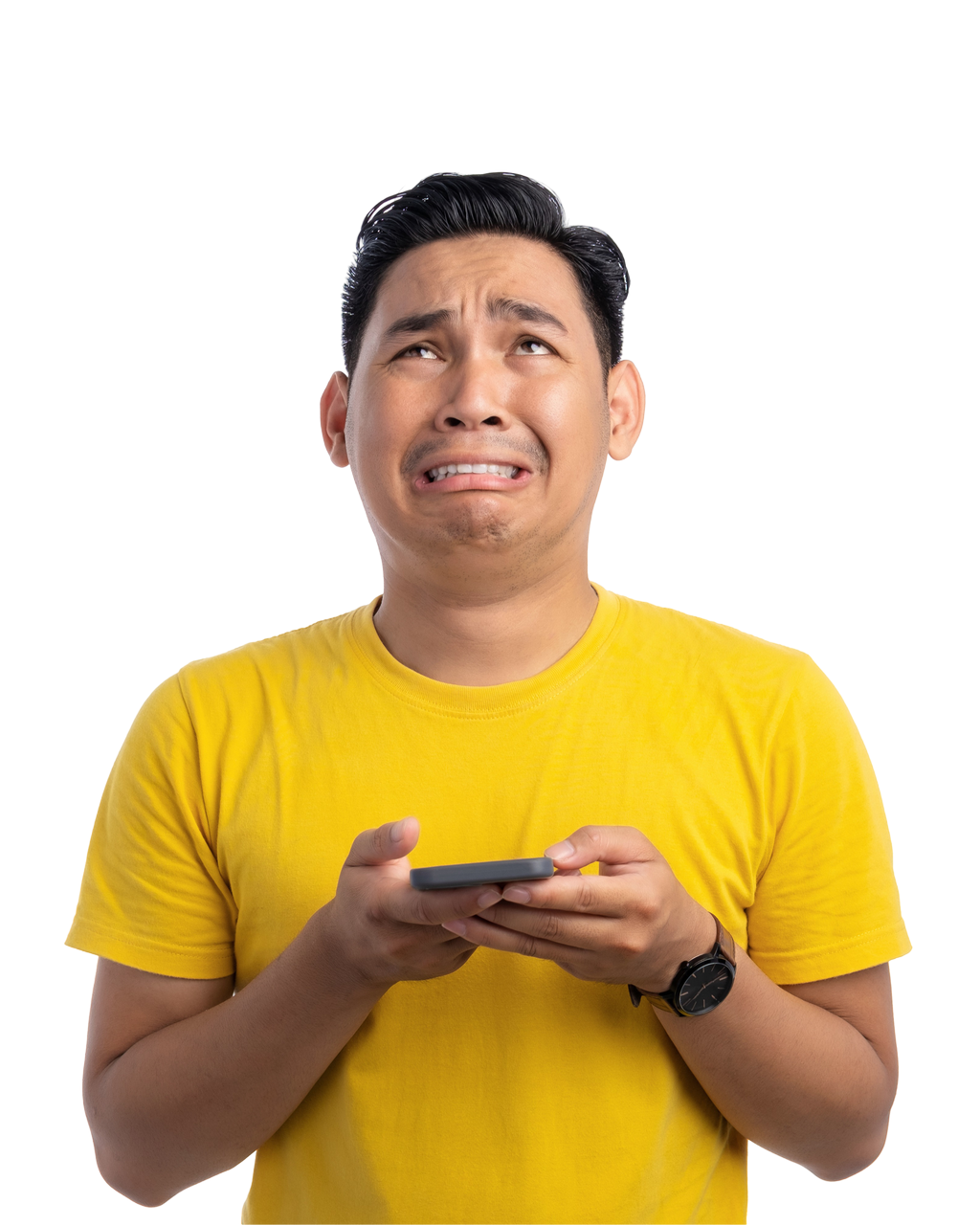 Un homme en chemise jaune lève les yeux en pleurant, tout en tenant un téléphone.