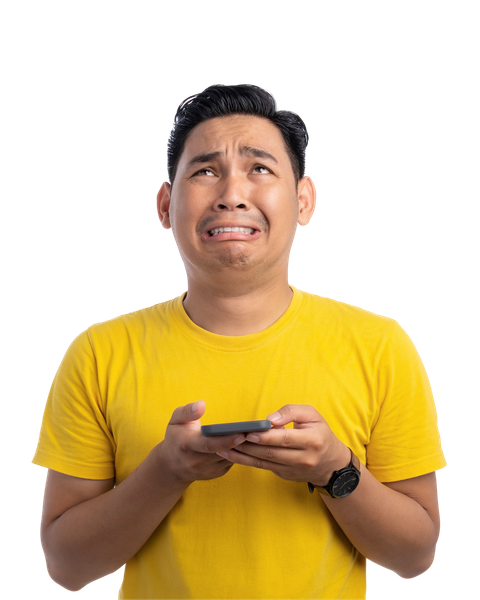 Un homme en chemise jaune lève les yeux en pleurant, tout en tenant un téléphone.