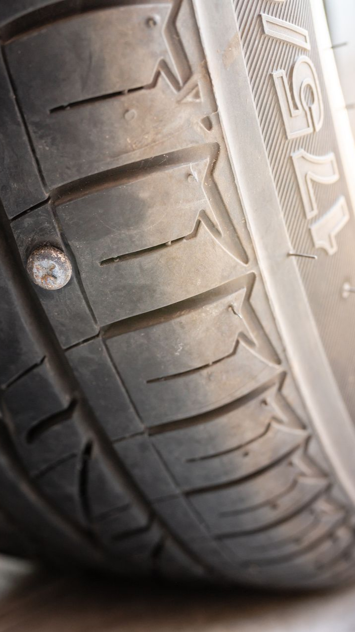 Pneu avec une vis logée dans la bande de roulement.