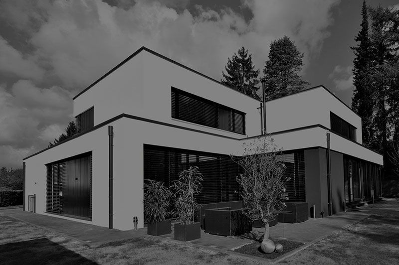 Ein Schwarzweißfoto eines modernen Hauses mit vielen Fenstern.