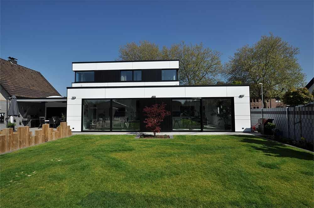 Ein großes weißes Haus mit einem großen Rasen davor.