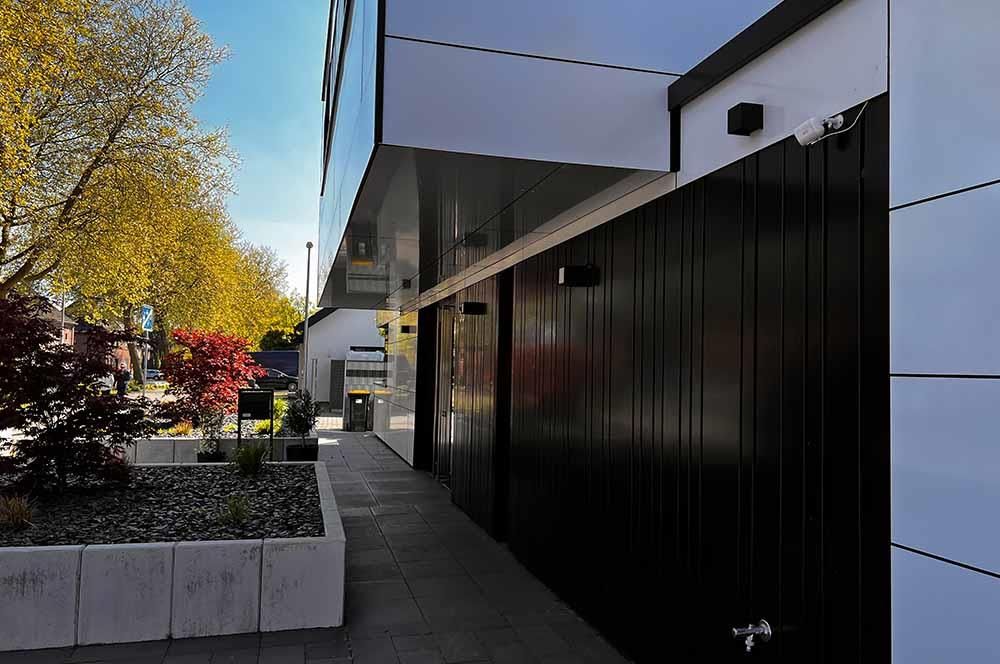 Ein schwarz-weißes Gebäude mit einem Blumenkasten davor