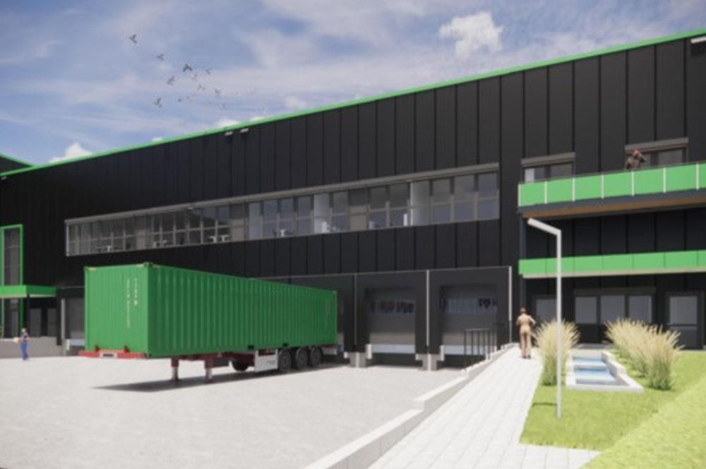 Ein grüner LKW steht vor einem großen Gebäude