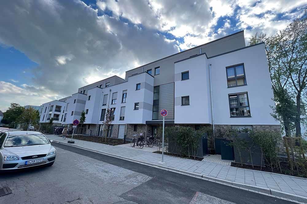 Ein weißes Auto steht vor einem großen weißen Gebäude