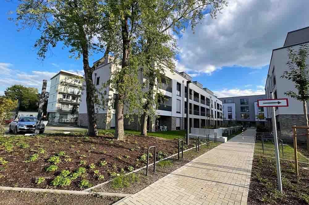 Ein großes Wohnhaus mit einem dorthin führenden Gehweg.