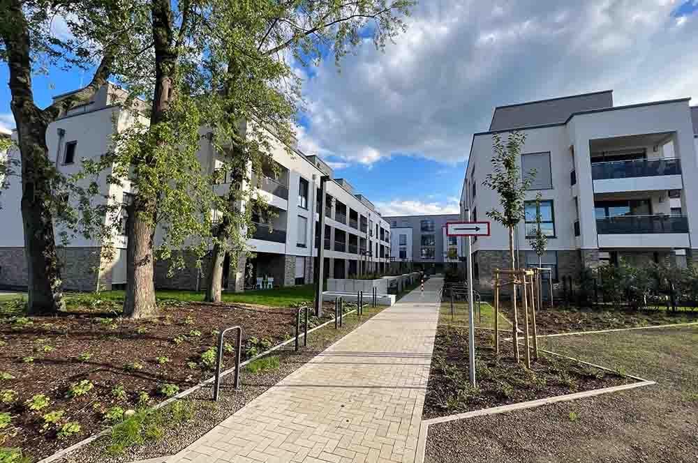 Ein großes Wohnhaus mit einem dorthin führenden Gehweg.
