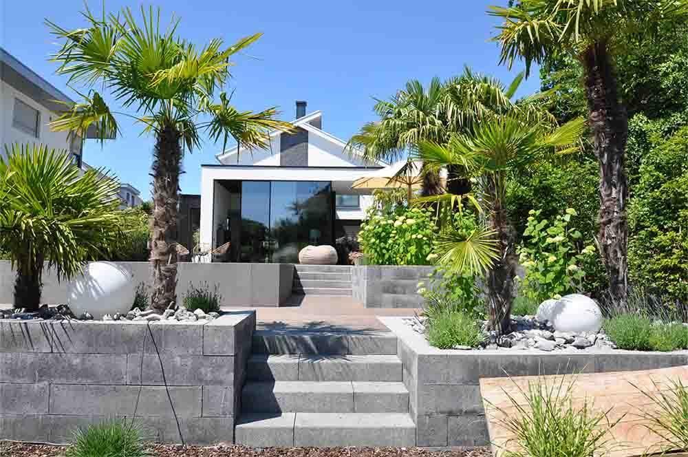 Ein Haus mit einer Treppe hinauf und Palmen davor