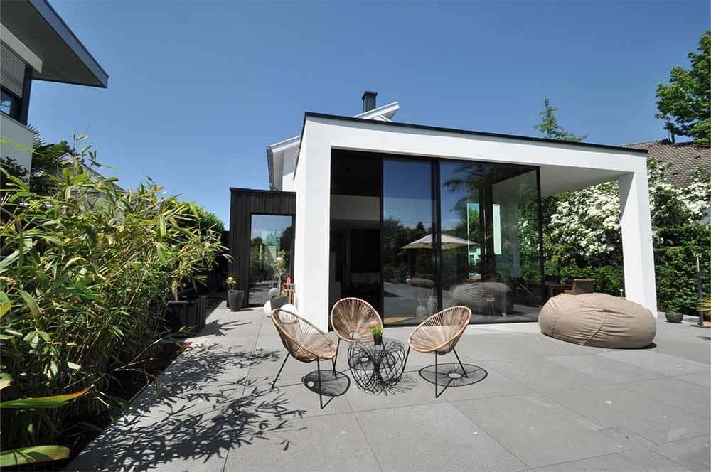Eine Terrasse mit Stühlen und einem Tisch vor einem Haus
