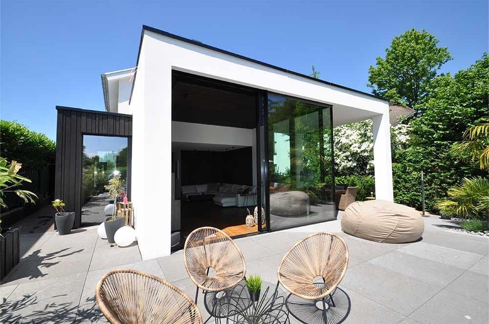 Eine Terrasse mit Stühlen und einem Tisch vor einem Haus