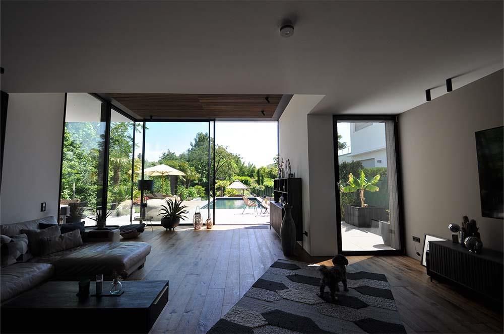 Ein Wohnzimmer mit einer großen Glasschiebetür, die zu einem Pool führt