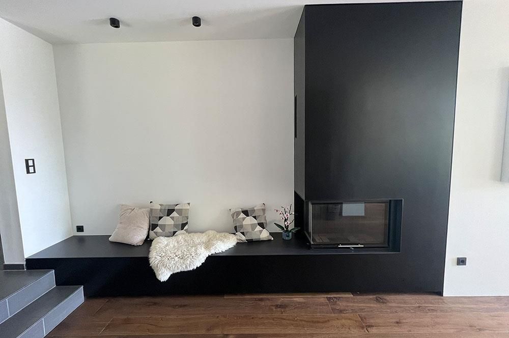 Ein Wohnzimmer mit Kamin und einer Couch mit Kissen darauf