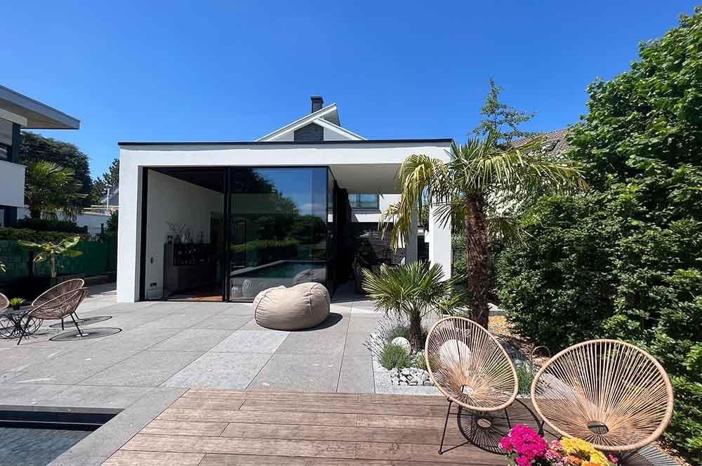 Ein Haus mit einem Swimmingpool und Stühlen davor