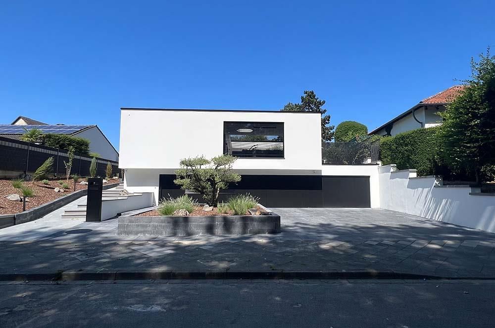 Ein großes weißes Haus mit einem schwarzen Garagentor