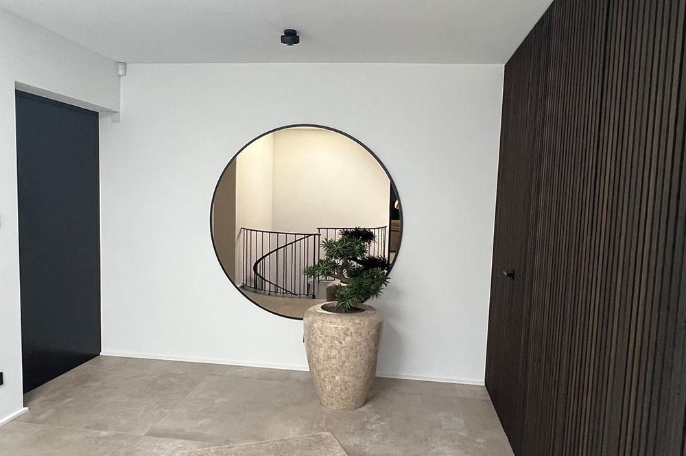 Ein Raum mit einem runden Fenster und einer Topfpflanze