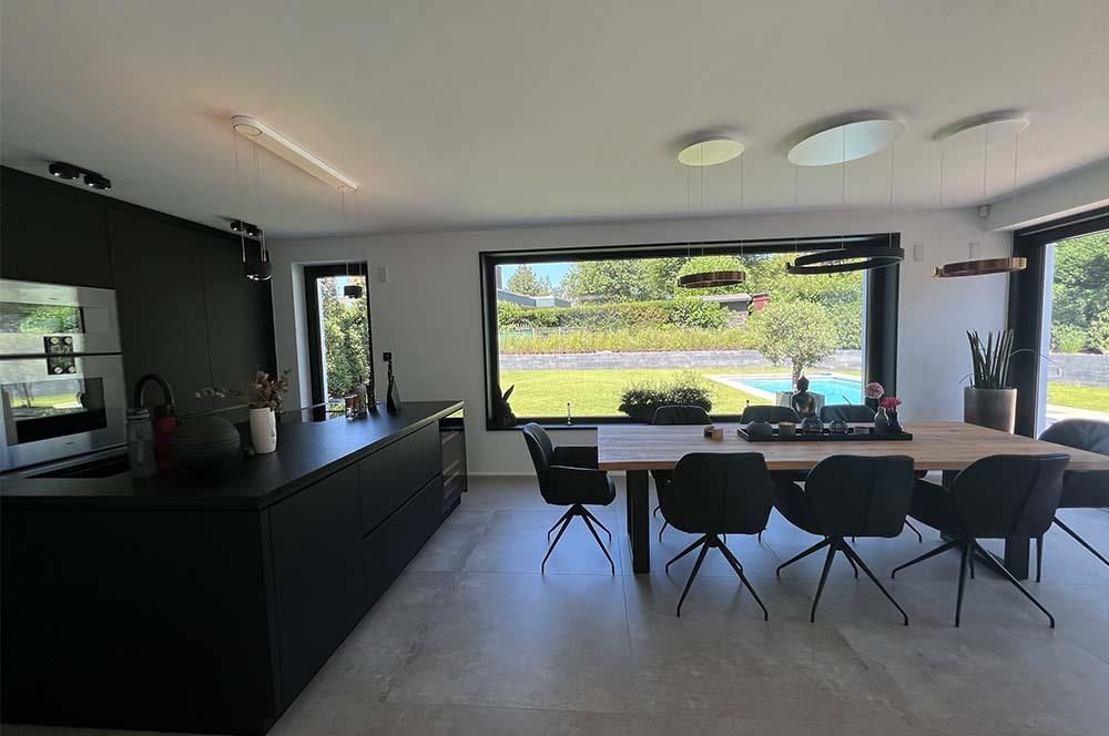 Eine Küche mit Tisch und Stühlen und einem großen Fenster