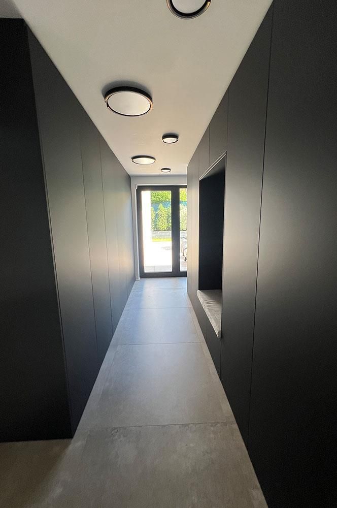 Ein Flur mit schwarzen Wänden und weißen Fliesenböden