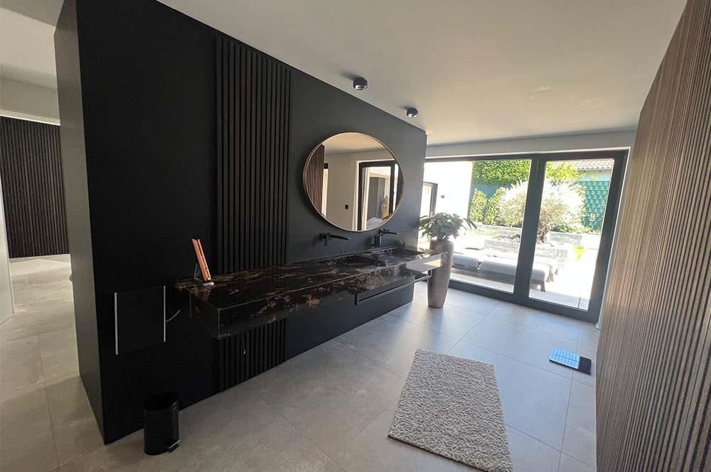 Ein Badezimmer mit einem großen Spiegel an der Wand