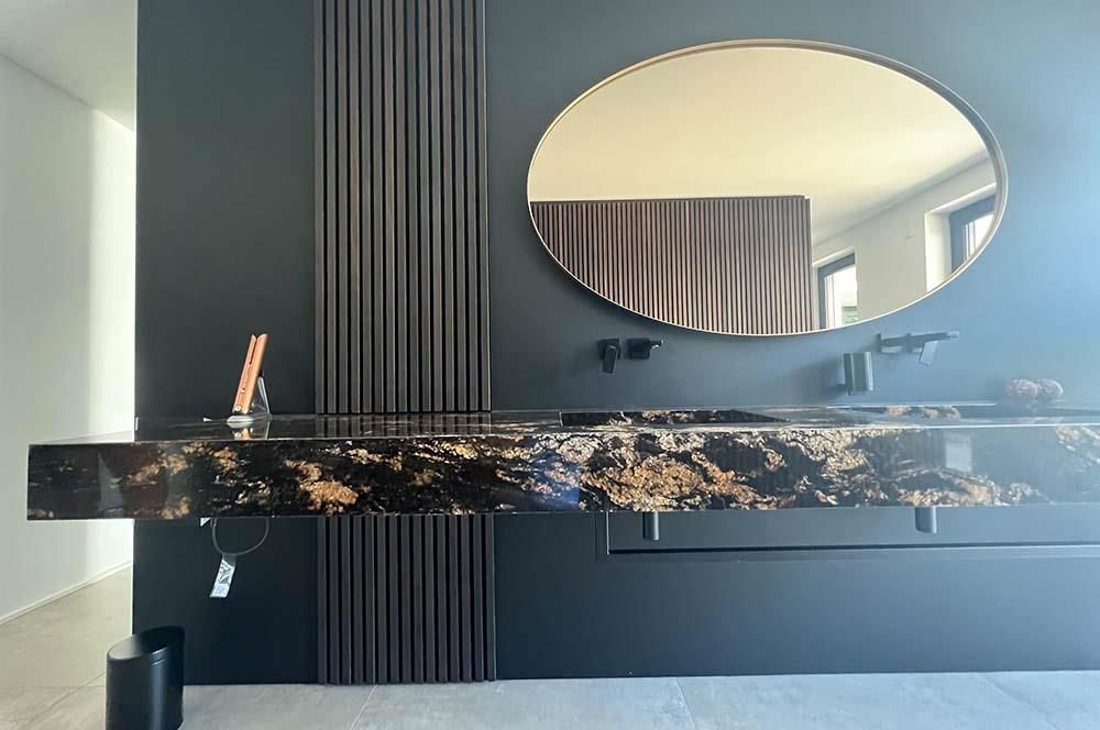 Ein Badezimmer mit Waschbecken und großem Spiegel