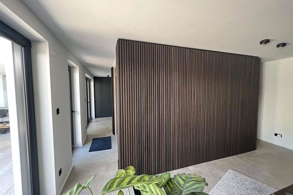 Ein Raum mit einer Holzwand und einer Pflanze davor