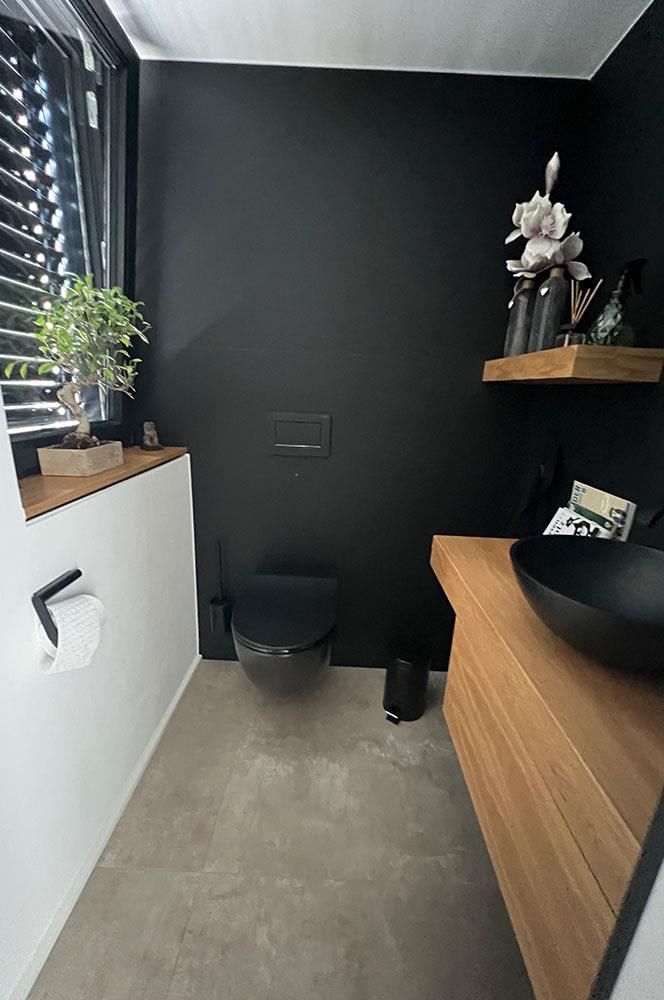 Ein Badezimmer mit Toilette, Waschbecken und Fenster.