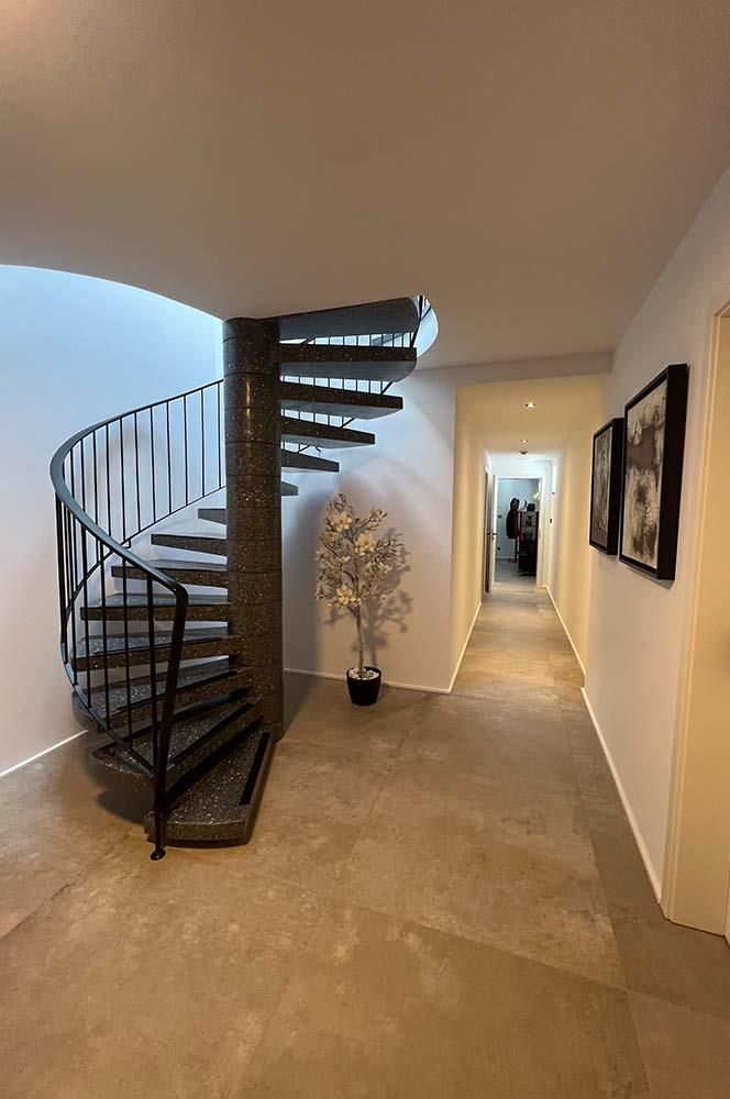 In der Mitte eines Flures befindet sich eine Wendeltreppe.