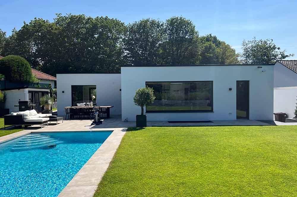 Ein weißes Haus mit einem Swimmingpool davor