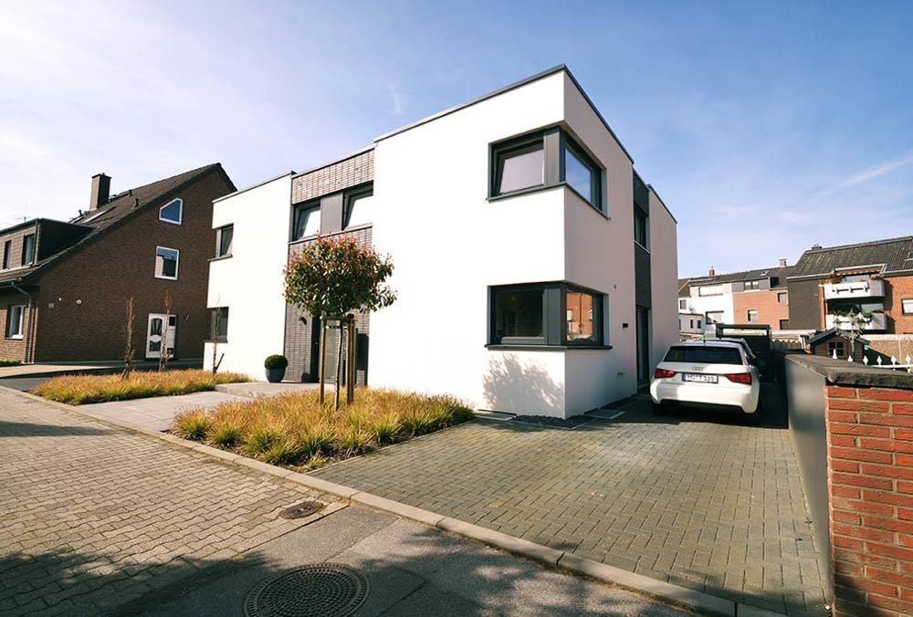 Ein weißes Auto steht vor einem weißen Gebäude