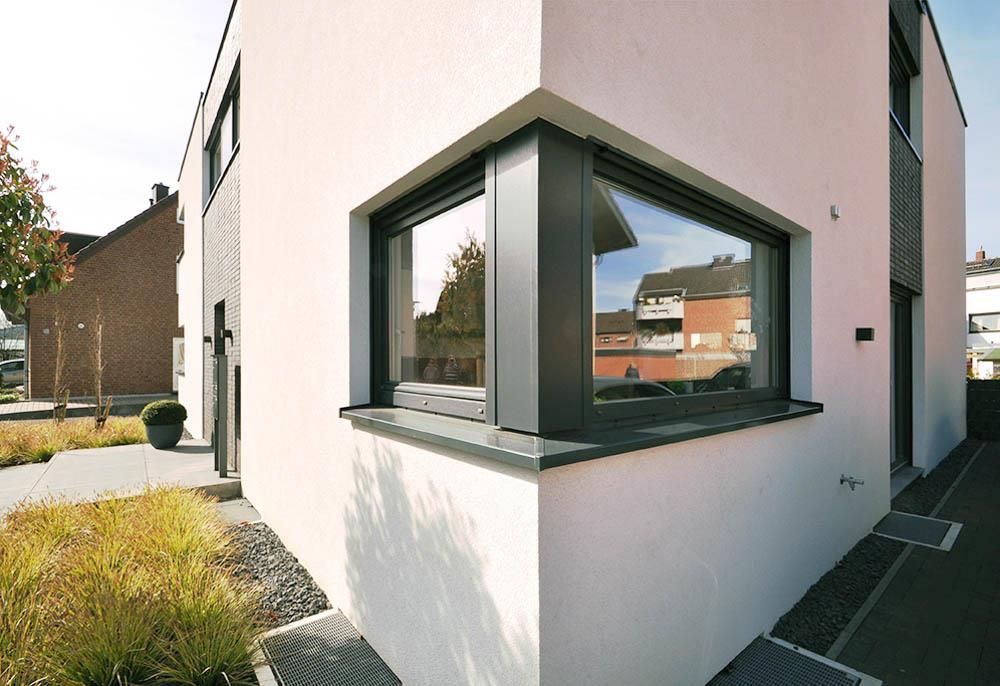 Ein weißes Haus mit einem großen Fenster an der Ecke