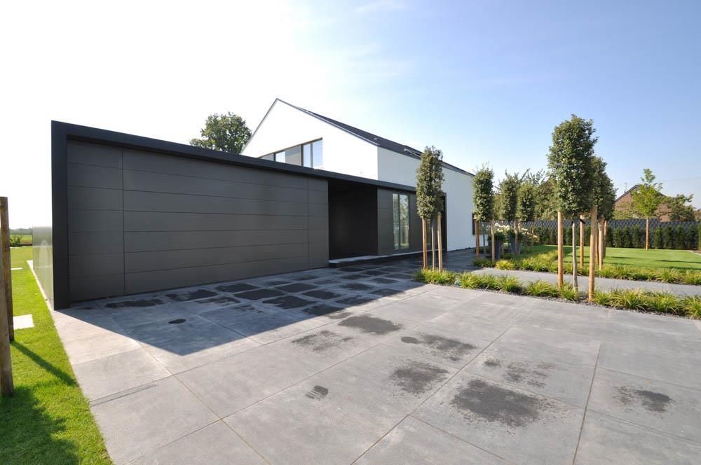 Ein modernes Haus mit einem großen schwarzen Garagentor