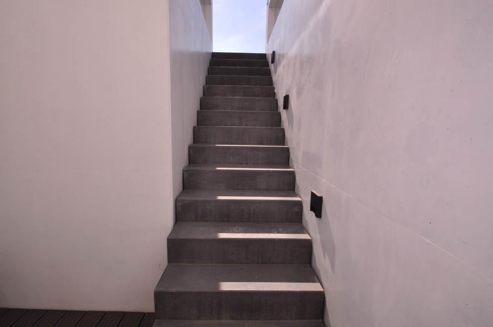 Eine Treppe führt zu einer weißen Wand hinauf.