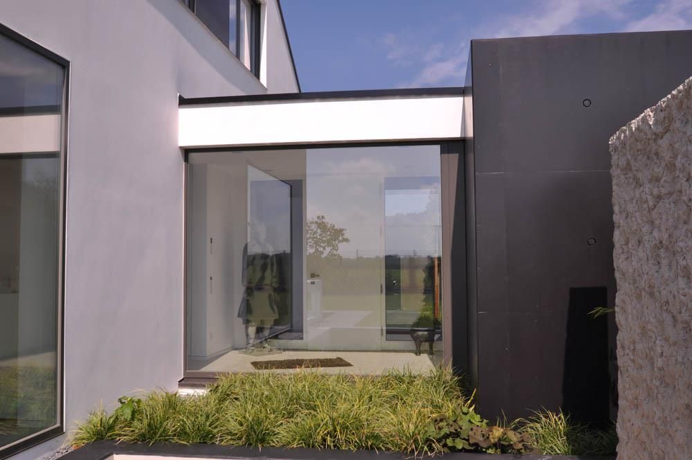 Ein Haus mit einer Glasschiebetür und einem großen Fenster