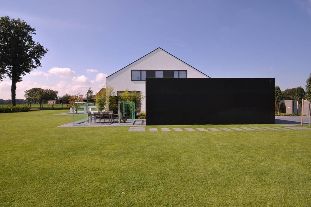 Ein weißes Haus mit einer schwarzen Wand davor