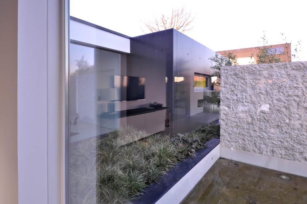 Blick durch ein Fenster auf ein Haus mit einem Fernseher an der Wand