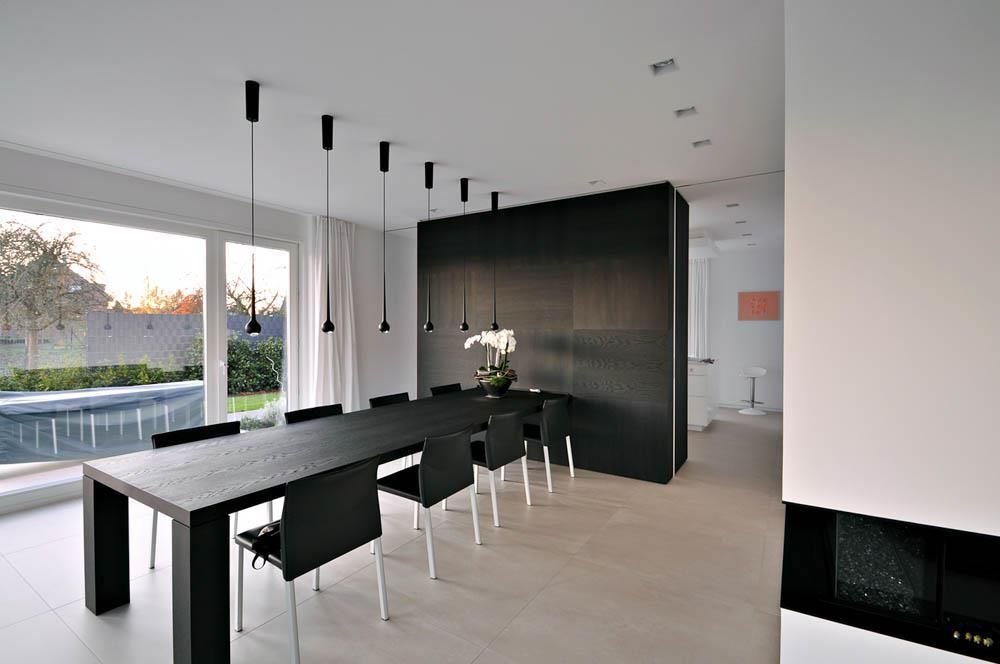 Ein Esszimmer mit einem langen schwarzen Tisch und Stühlen