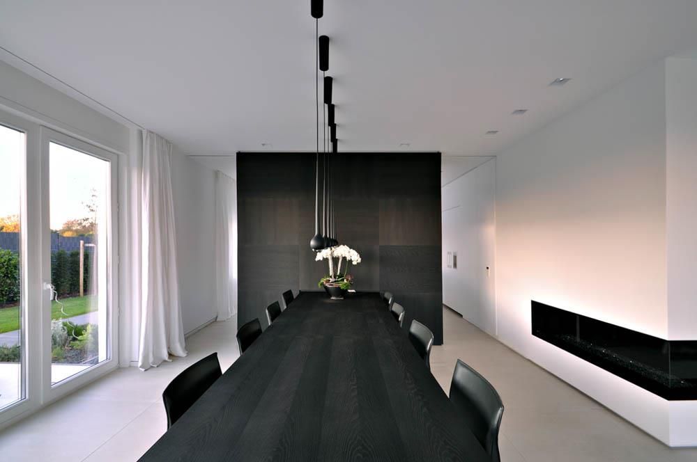 Ein Esszimmer mit einem langen schwarzen Tisch und Stühlen