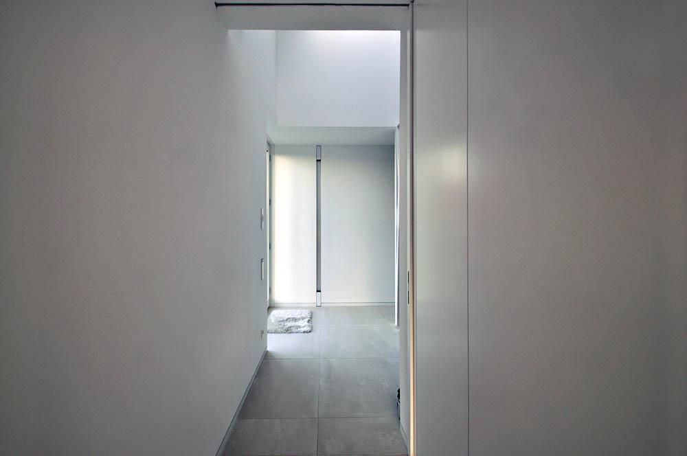 Ein Flur in einem Haus mit einer Tür, die zu einem Zimmer führt.