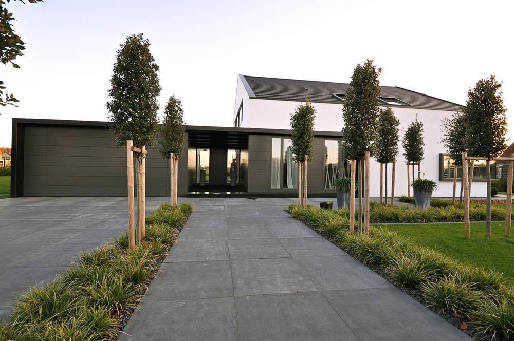 Eine Auffahrt, die zu einem Haus mit Bäumen davor führt