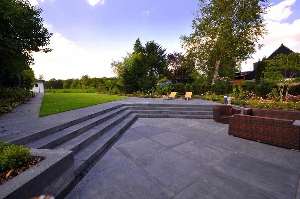 Eine Terrasse mit Treppen, die zu einer Wiese führen