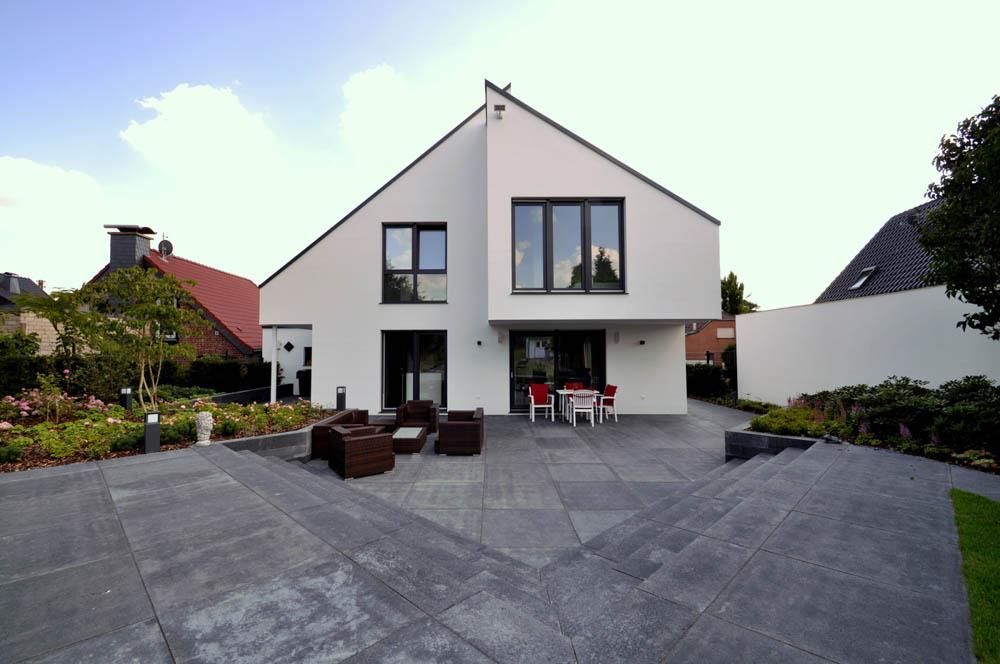 Ein großes weißes Haus mit einer Terrasse davor