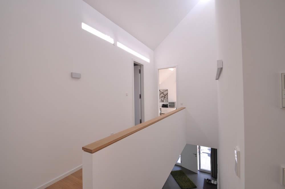 Ein Flur mit weißen Wänden und einem Holzgeländer