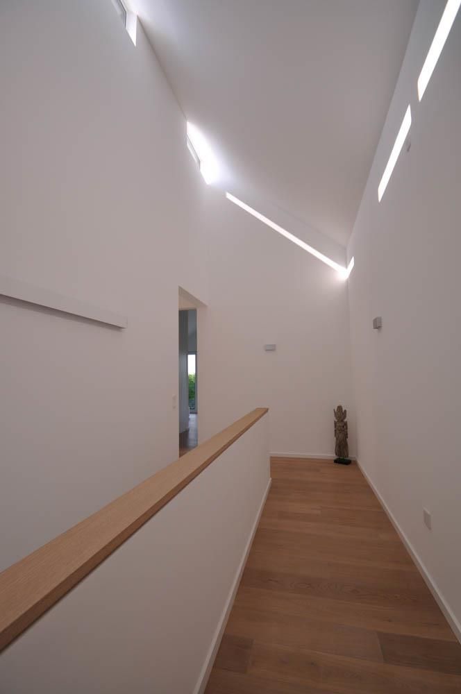 Ein Flur mit Holzboden und weißen Wänden