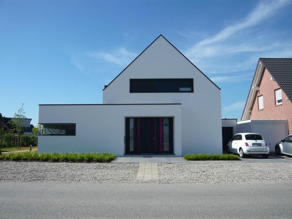 Ein weißes Auto steht vor einem weißen Haus