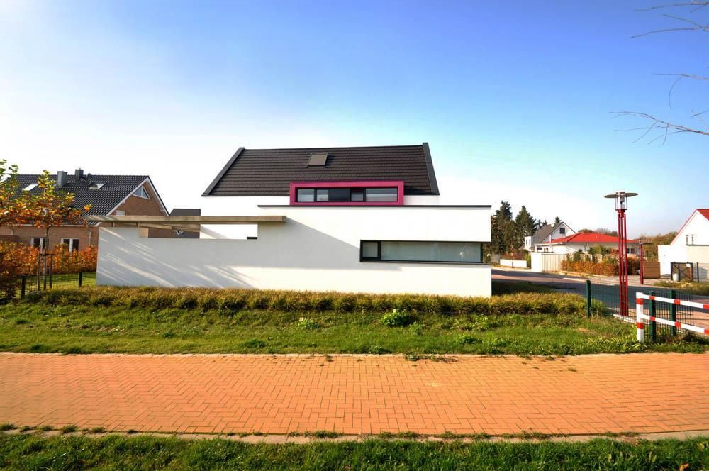 Ein weißes Haus mit einer rosa Verzierung auf dem Dach