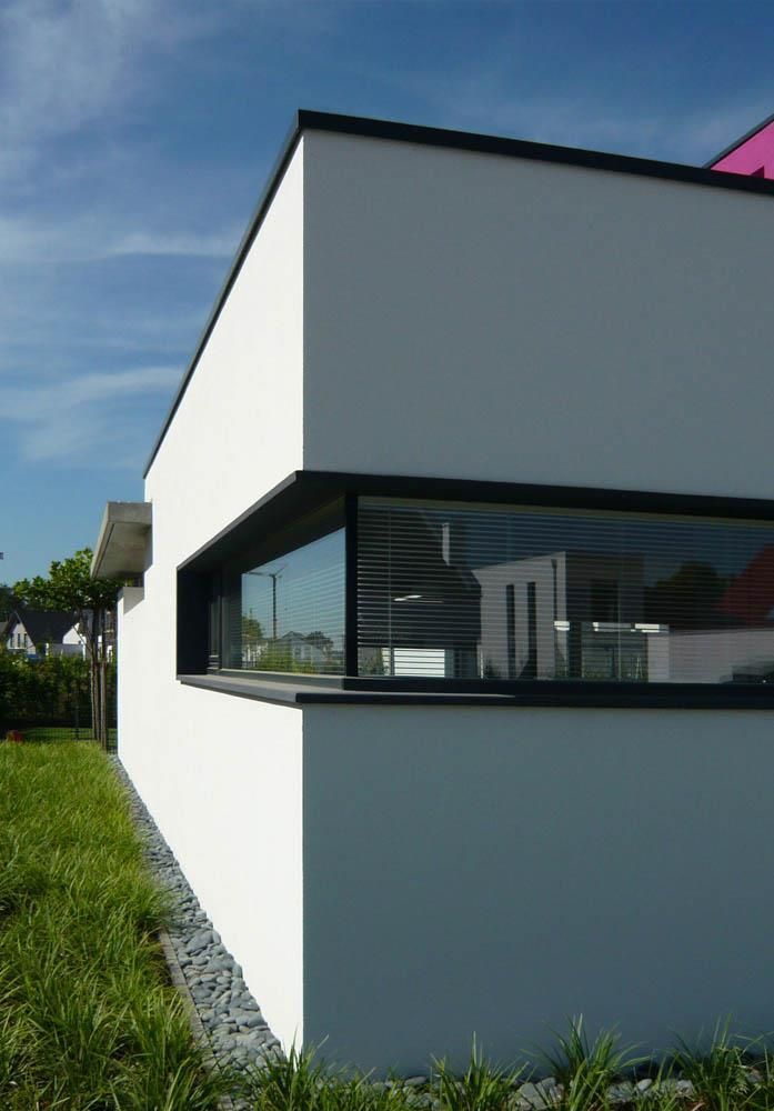 Ein weißes Gebäude mit einem großen Fenster an der Seite