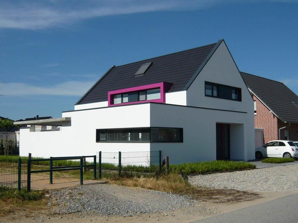 Ein weißes Haus mit einem rosa Fenster und einem schwarzen Dach