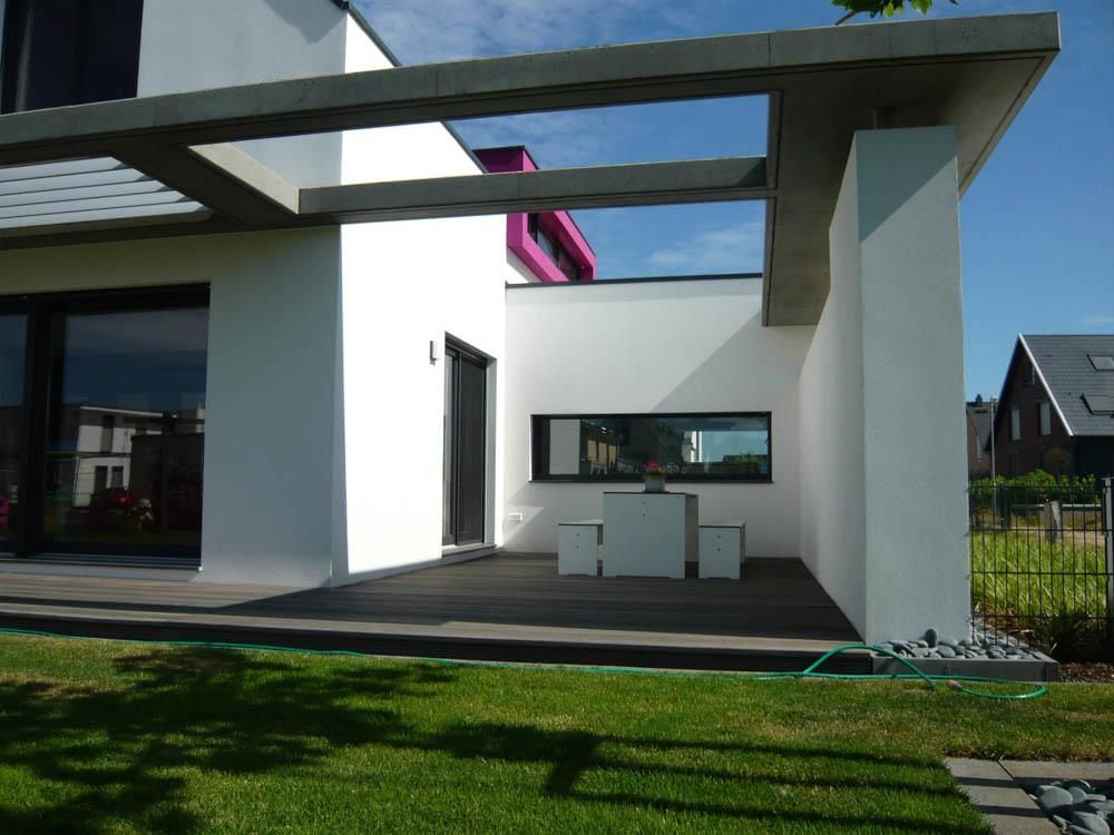 Ein weißes Haus mit einer Terrasse und einem Schlauch davor