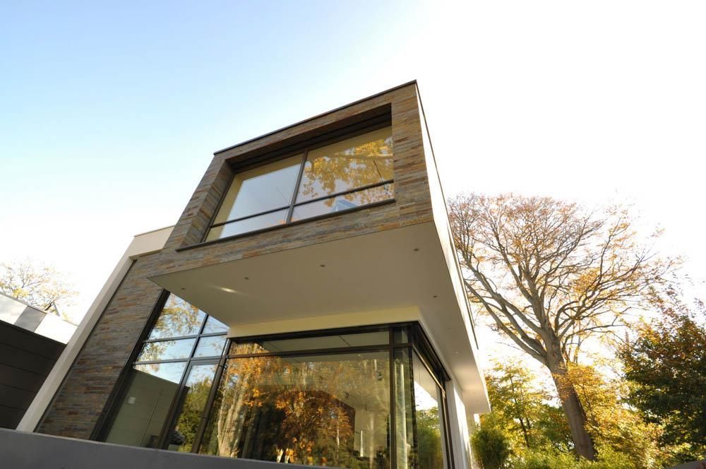 Ein modernes Haus mit vielen Fenstern und Bäumen im Hintergrund